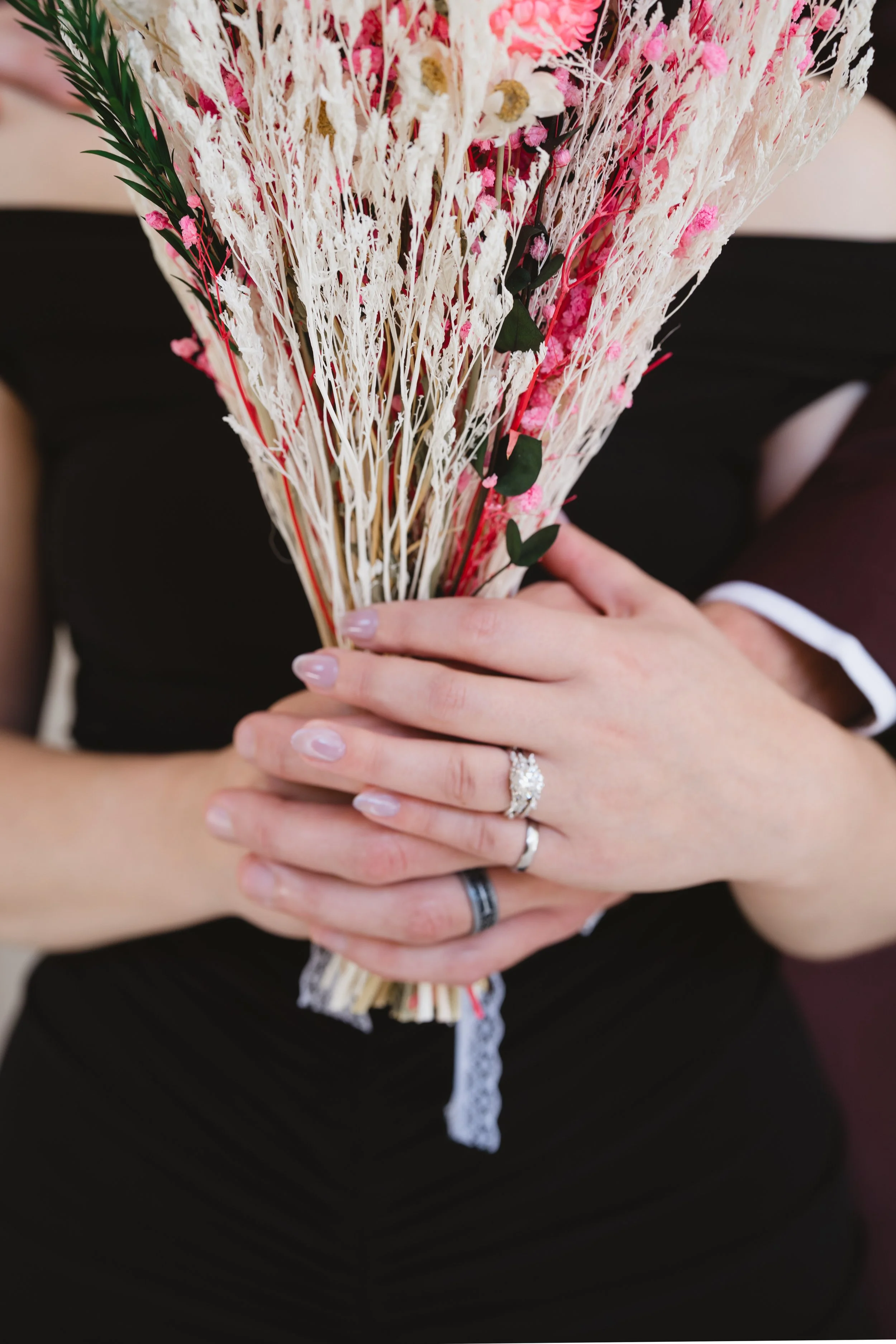 Wedding rings and dried flower bouquet close-up