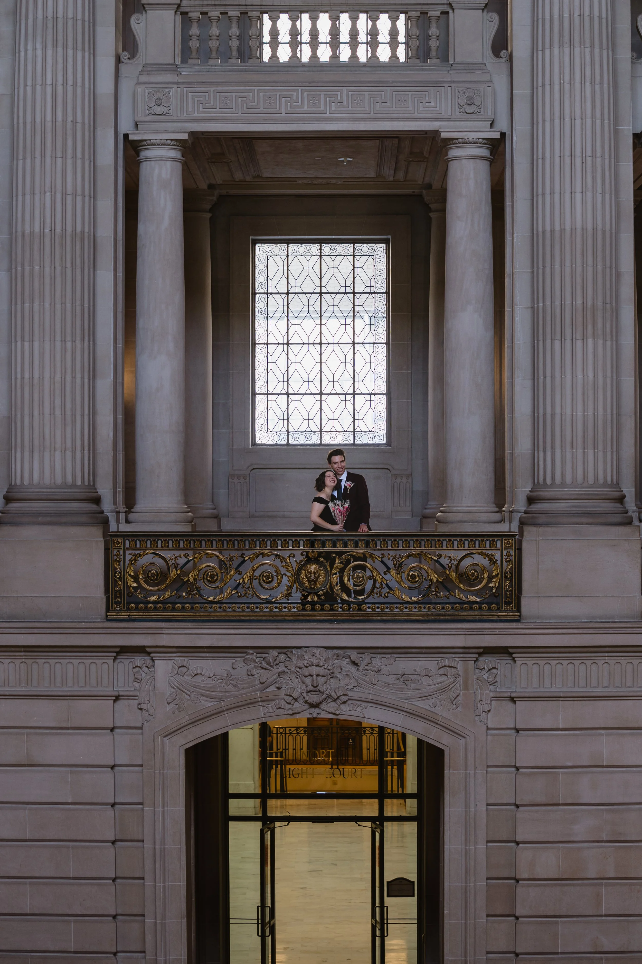 newly wed couple on balcony in san francisco city hall
