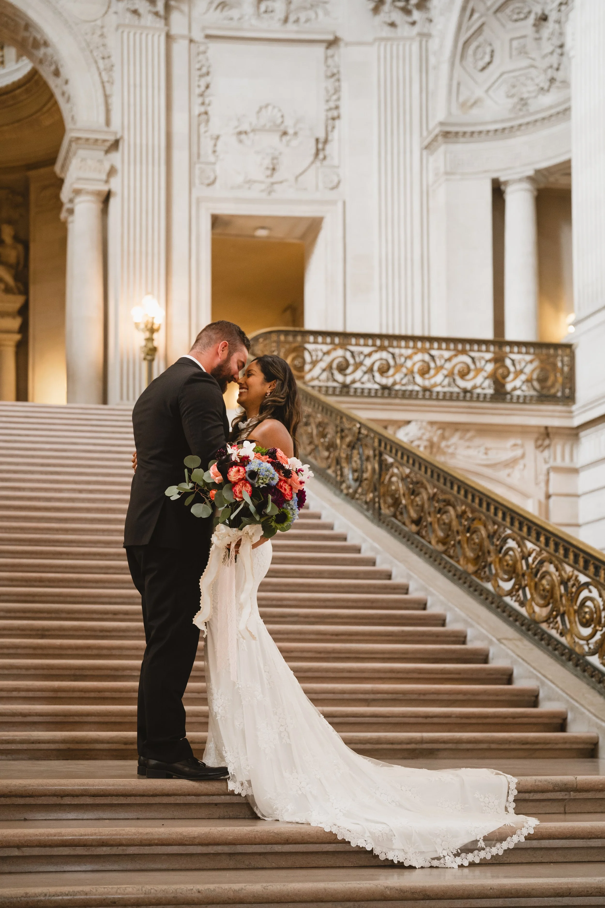 Couple kissing partway up the Grand Staircase, viewed from the base of the stairs.