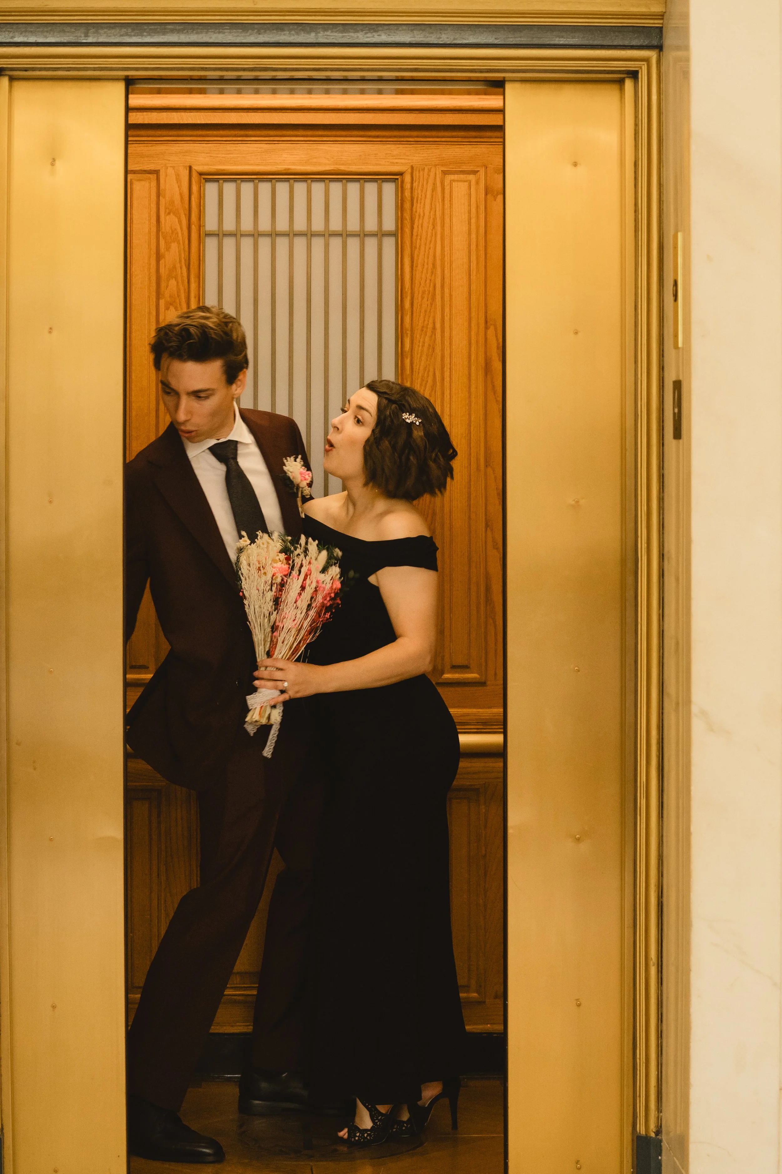 Playful couple photo in the brass elevator at SF City Hall