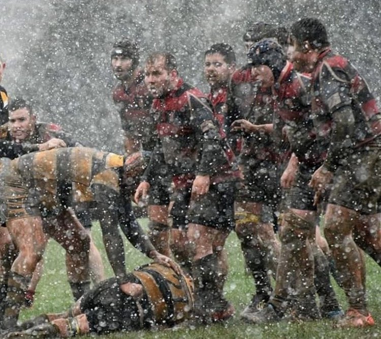 Clane RFC players packing down a scrum in heavy rain