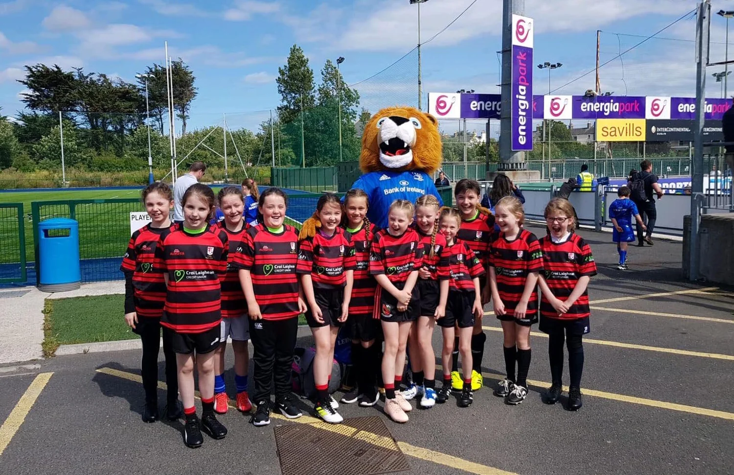 Clane girls in red and black with the Leinster Rugby mascot