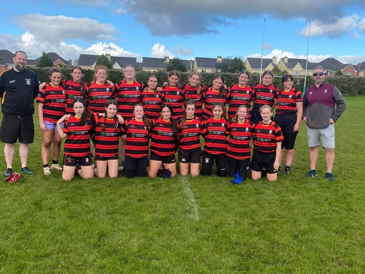 Clane RFC girls' squad in red and black with their coach