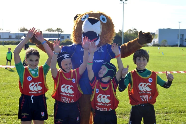 Clane minis players cheering with the Leinster Rugby mascot