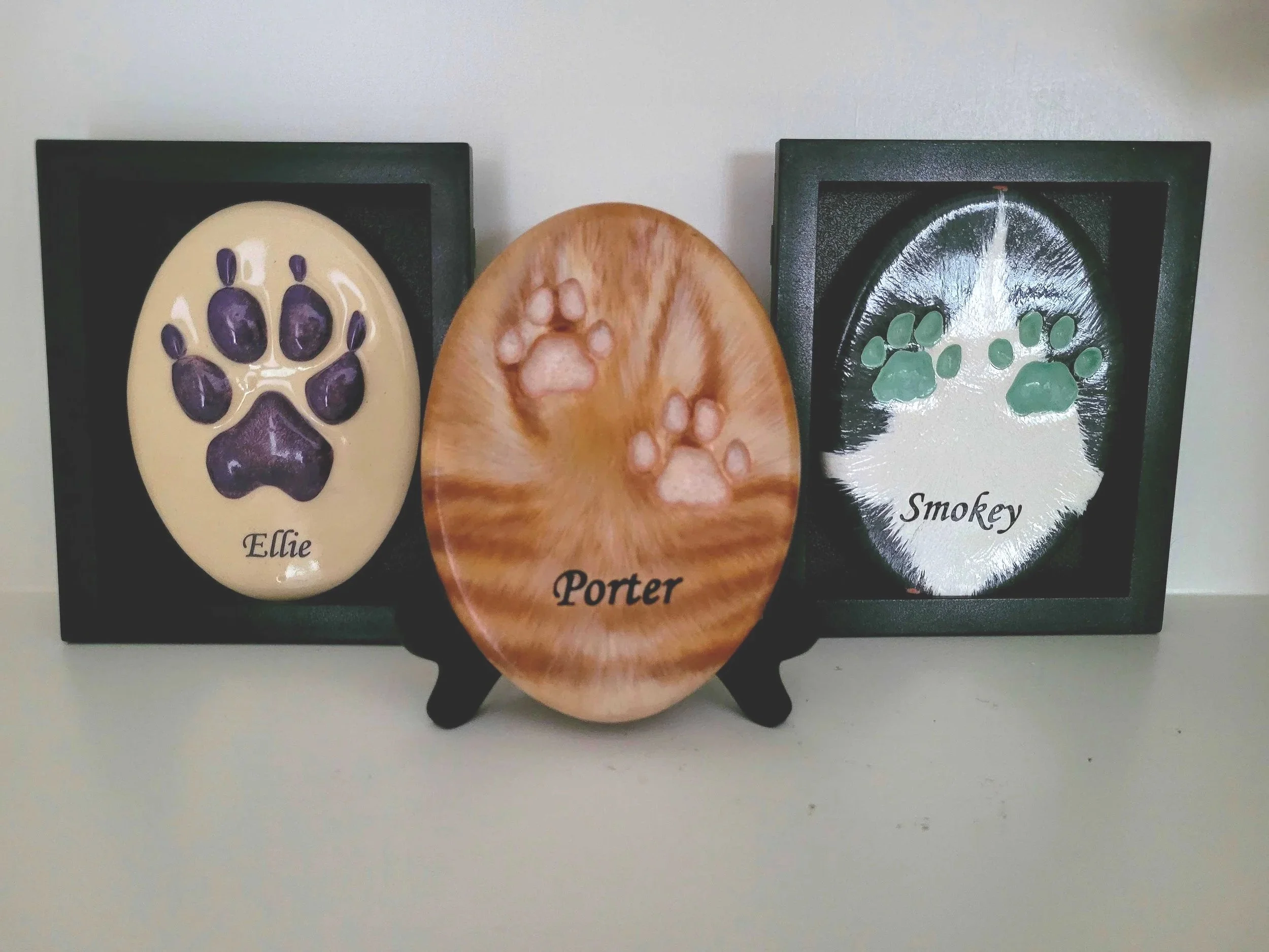 ceramic pet paw prints of Ellie a Golden Retriever Dog in 3D, Porter a Ginger Tabby Cat and Smokey a grey & white cat, both created as custom made fur matching design