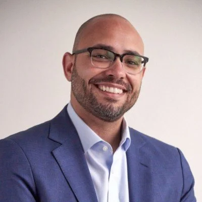 Smiling man wearing glasses and a blue suit