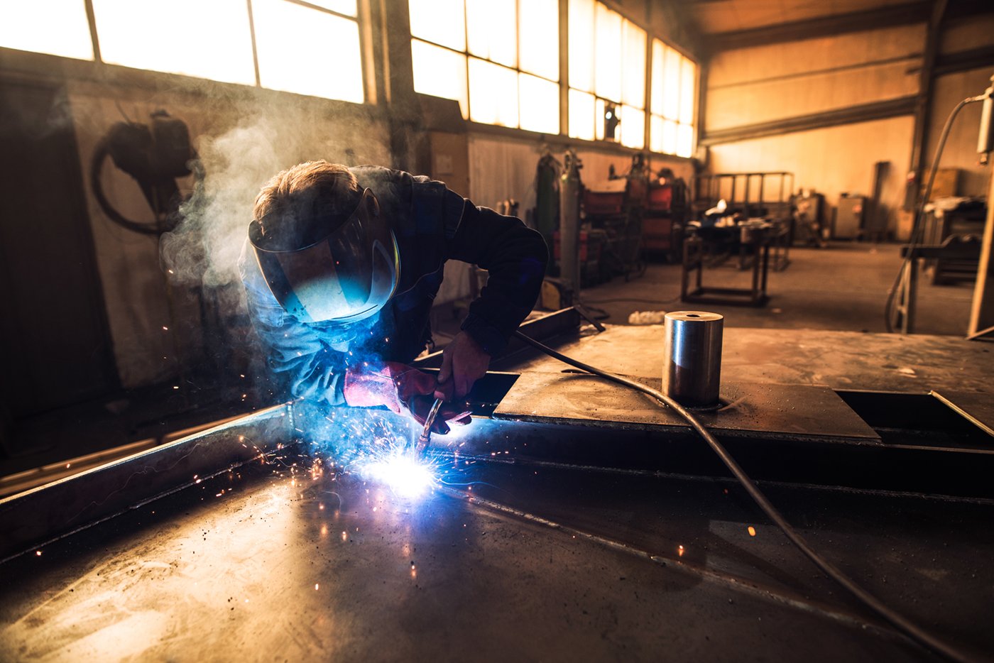 Worker welding metal in a workshop