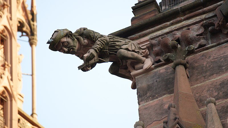  Exterior view and gargoyle of the Freiburg Minster, Freiburg im Breisgau in Germany. Human-like reading creature as gargoyle by Asurnipal. This file is licensed under the  Creative Commons   Attribution-Share Alike 4.0 International  license.    