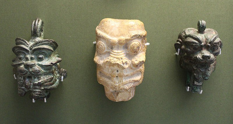  Pazuzu heads, aimed at protecting against the demoness Lamashtu. The metal ones were meanted to be incorporated in jewellery, the one in stone probably to be hung up in the house, especially in the bedroom. From Iraq, 900-500 BC. 