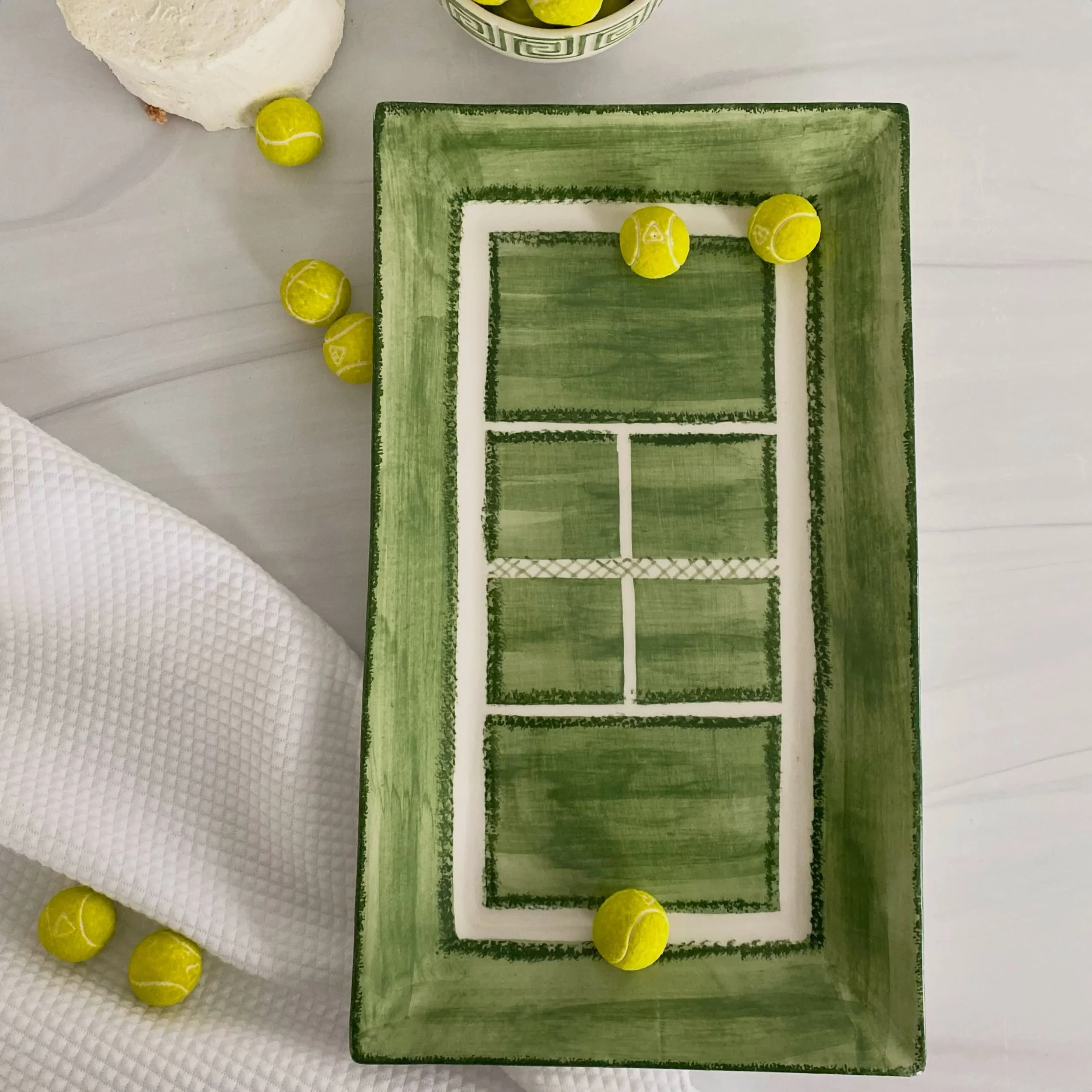 Luciano hand-paints the grass court pattern, line by line.