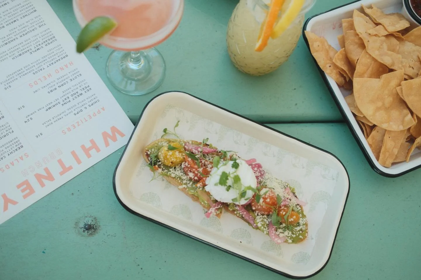 At Whitney&rsquo;s, it&rsquo;s summer every day.🦩🥭🌊🍋&zwj;🟩 
Great company, good food, good drinks, and really cool merch. @for.theloveof.film 
Live music tonight with Zion Albert, 6-9pm