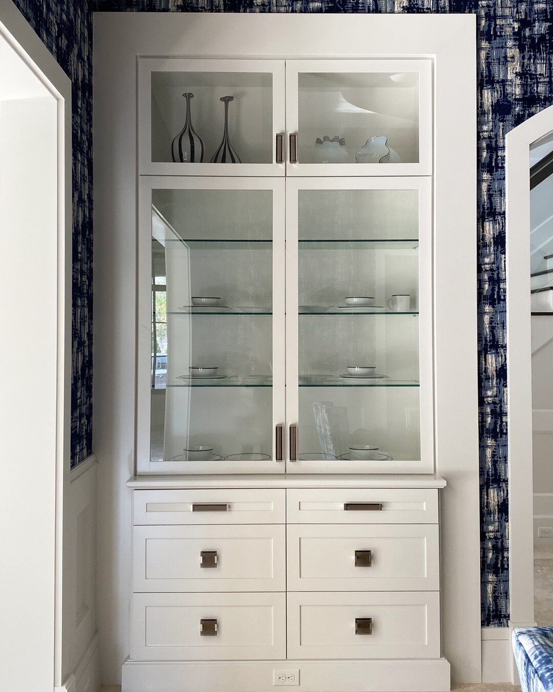 There's been a huge push for minimalism and downsizing, but I still love to have a place to put fine china or knickknacks. In this dining room, we designed sleek matching hutches for either side of the archway. We made sure to keep the lines clean an