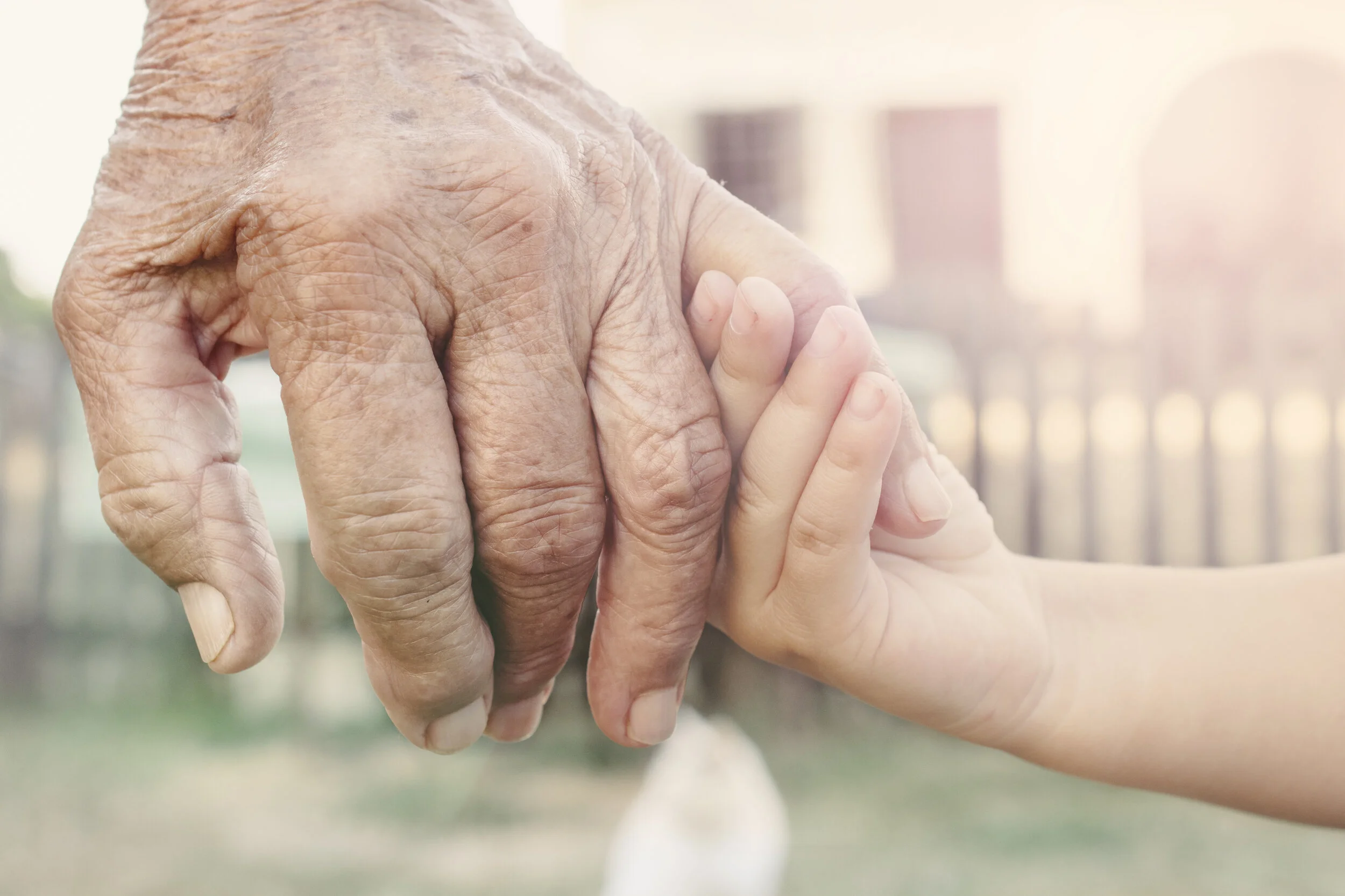 child holding an elderly person’s hand