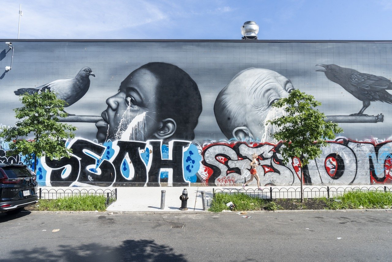 Defased mural depicting Notorious BIG and Alfred Hitchcock by Own Dippie, Decatur St. and Broadway, Brooklyn, August 14, 2023.