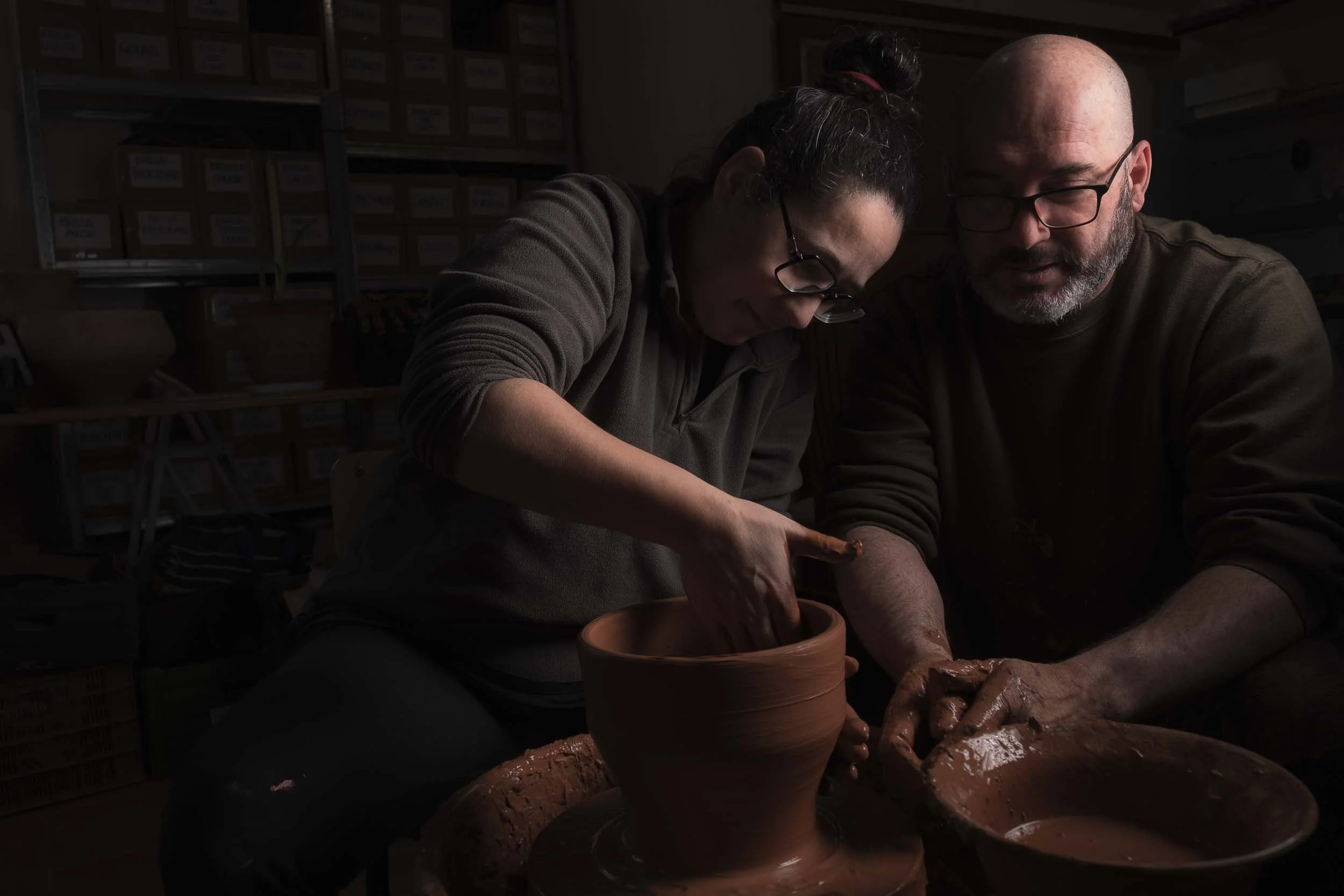 Maica y Marcelo, alfareros de Esquina Atlántica, trabajando simultáneamente en sus tornos. Una imagen que refleja la colaboración y la tradición compartida en el taller.

Título Squarespace: Pasión compartida.