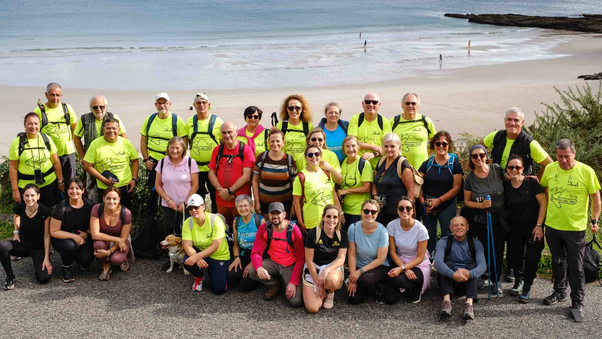 Peregrinos recorriendo las playas del Camiño do Mar en Burela, A Mariña Lucense.