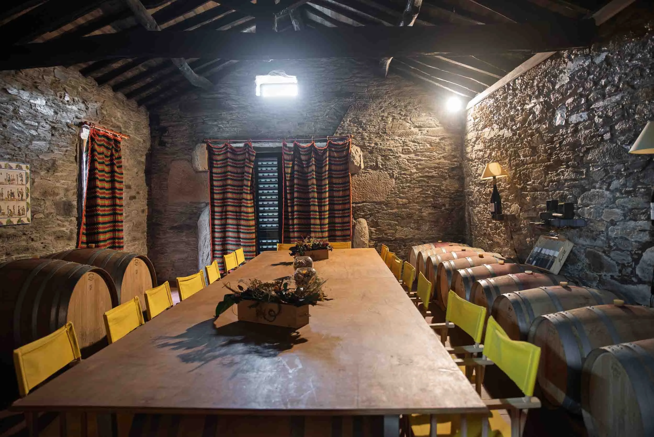 Vista de los interiores de la bodega tradicional en Quinta do Monte Travesso, combinando piedra y madera.