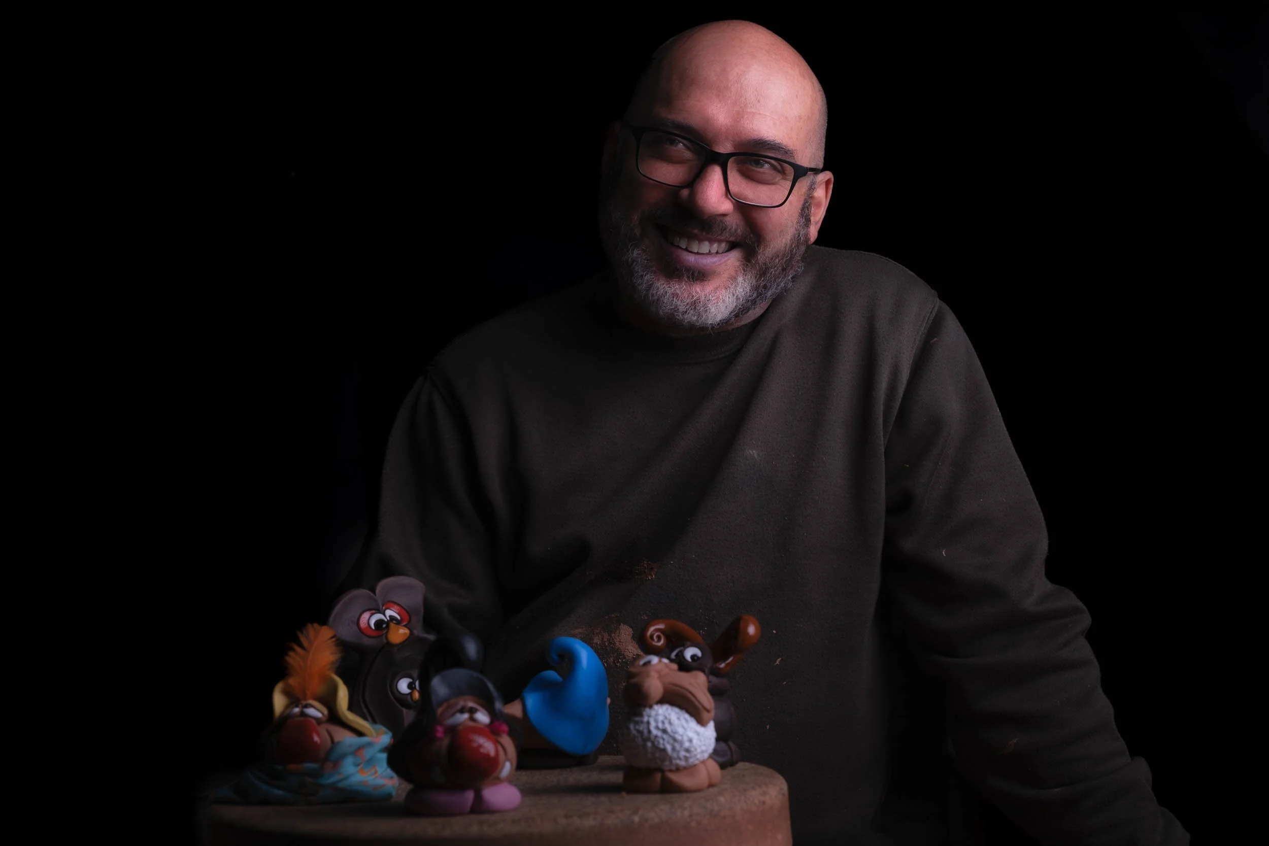 El alfarero Marcelo posando junto a una selección de sus piezas de cerámica más populares en el taller de Esquina Atlántica.