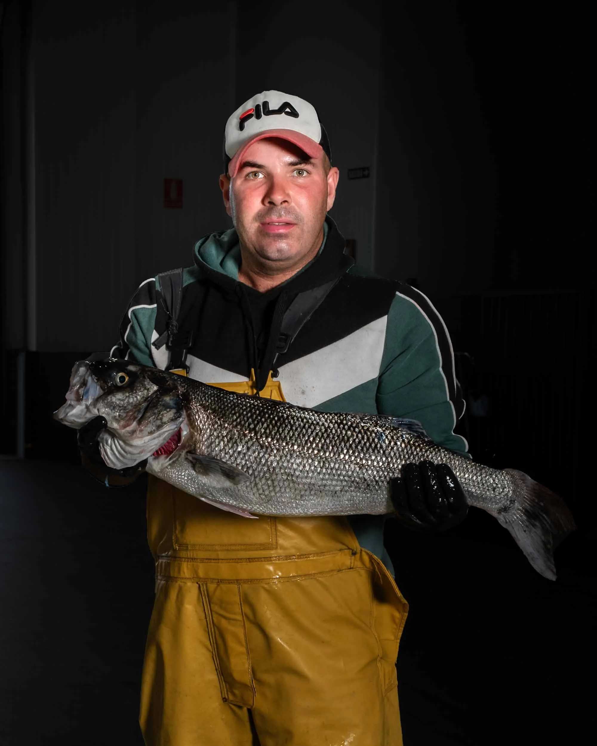 Pescador gallego sosteniendo una gran lubina salvaje, mostrando una captura premium de Cedeira.