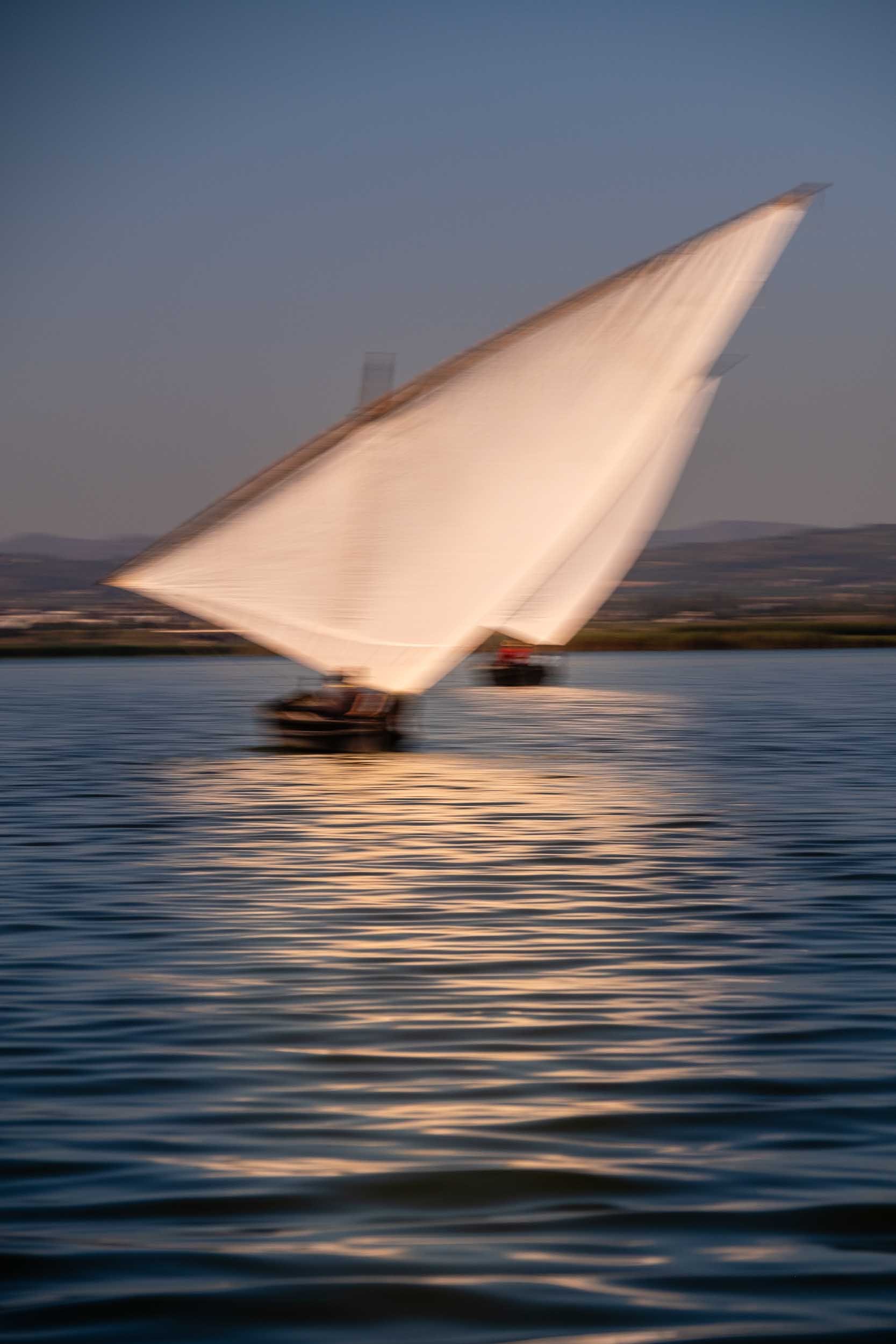 Composición creativa de una barca de vela latina, resaltando la silueta y la tradición marinera con un enfoque artístico.