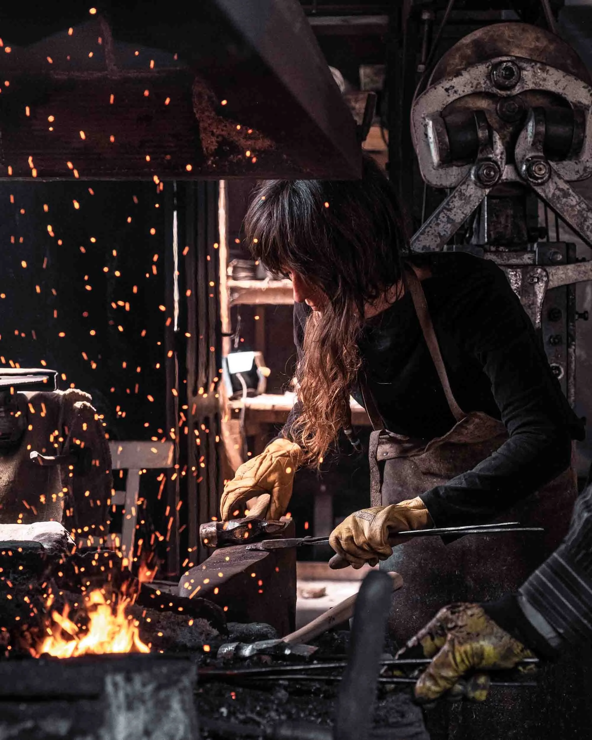 Retrato de una herrera trabajando en la fragua y aprendiendo técnicas de forja, visibilizando la mujer en oficios tradicionales.