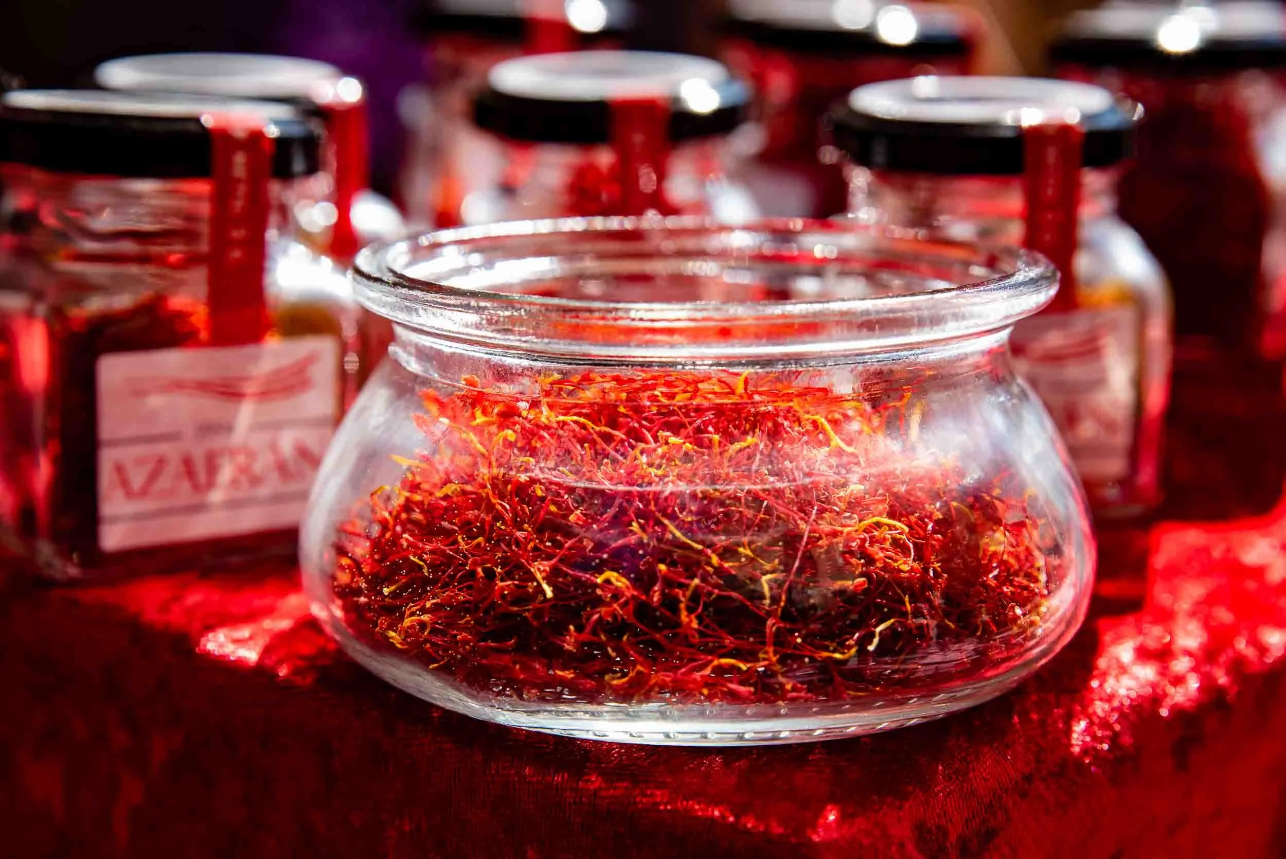 Proceso de envasado manual de hebras de azafrán puro en frascos de cristal para su conservación.