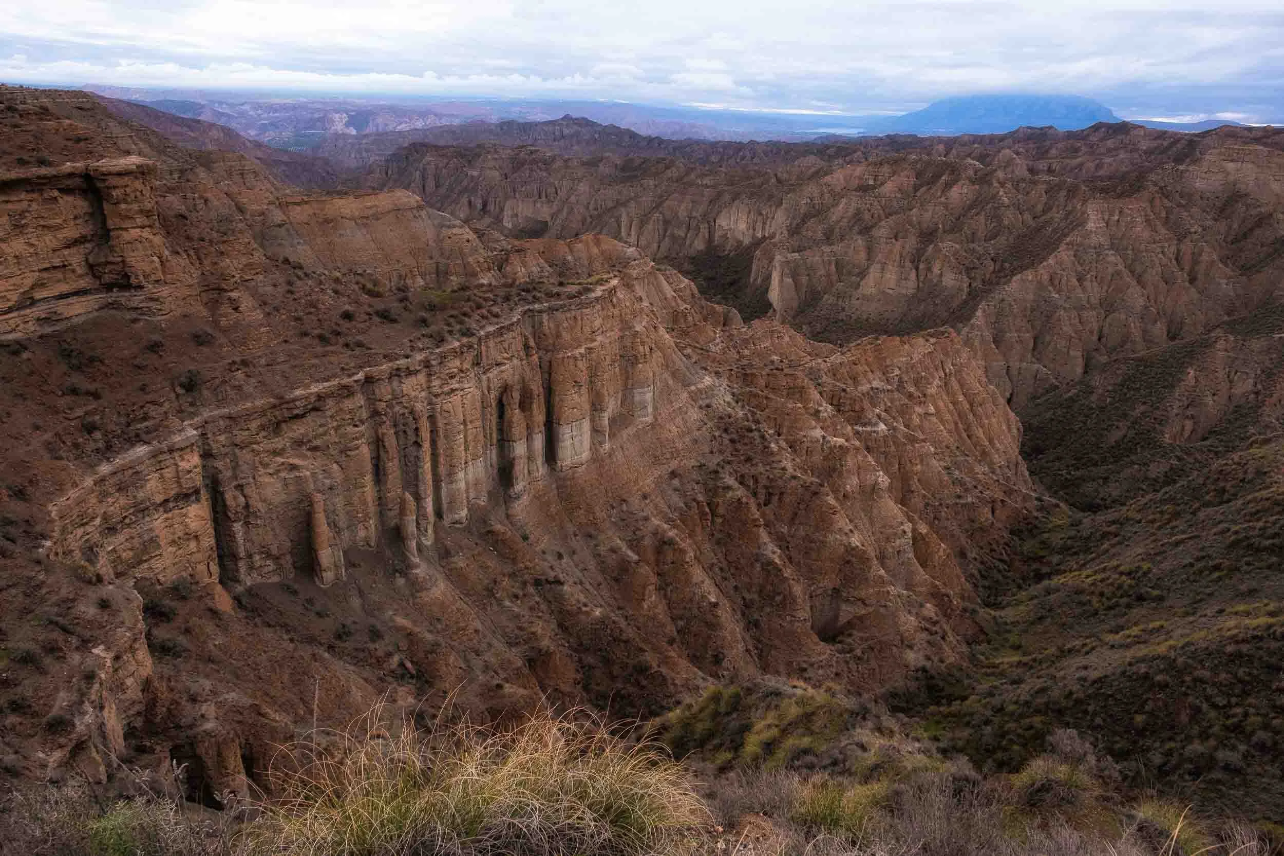 Paisaje geológico del Desierto de Gorafe en Granada, mostrando las formaciones de badlands bajo una luz dramática de atardecer.