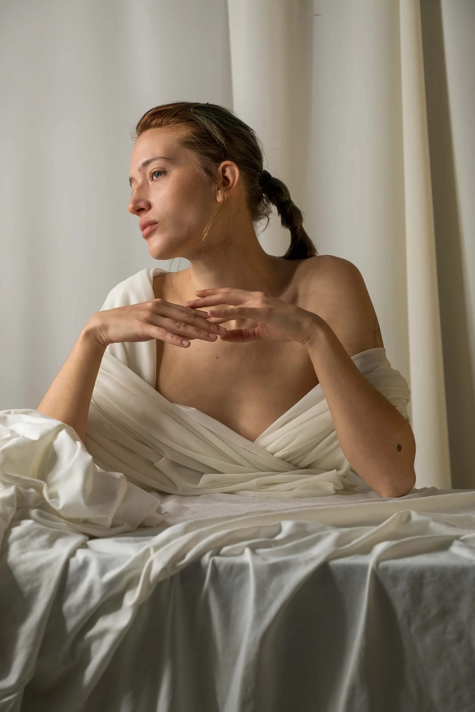 Modelo posando durante el amanecer con luz dorada suave, fotografía de retrato artístico en exterior por Photorural.