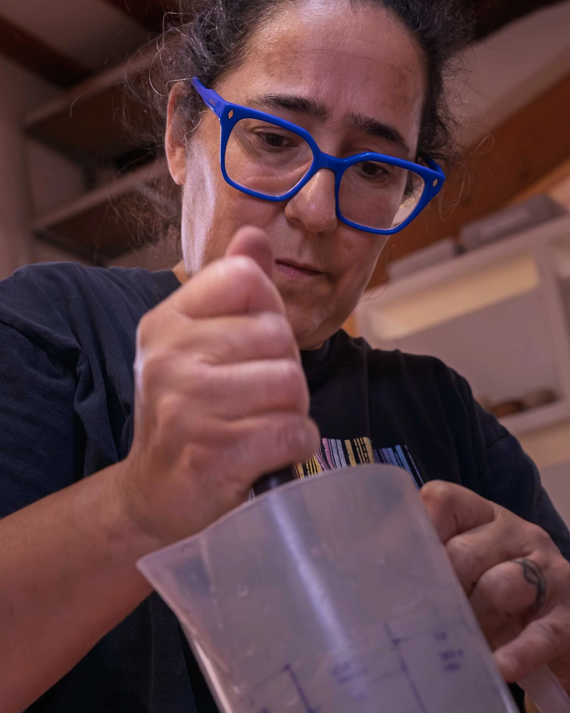 Retrato de la artesana Maica trabajando con pigmentos y herramientas en el Alfar Os Muíños.