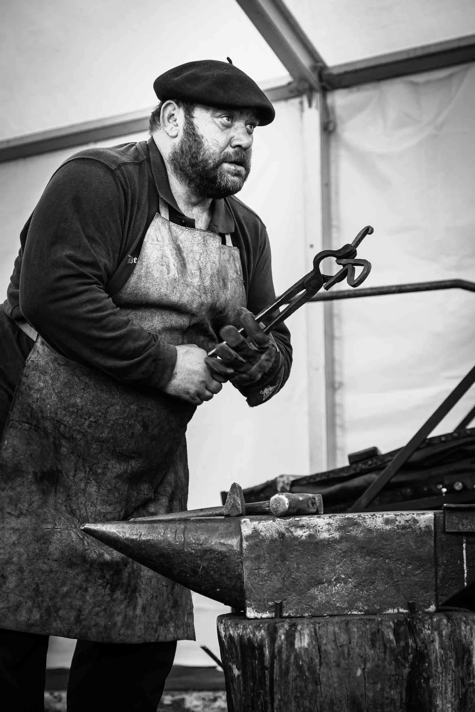 Pieza de metal al rojo vivo saliendo de la fragua antes del forjado, fotografía de alta temperatura y contraste.