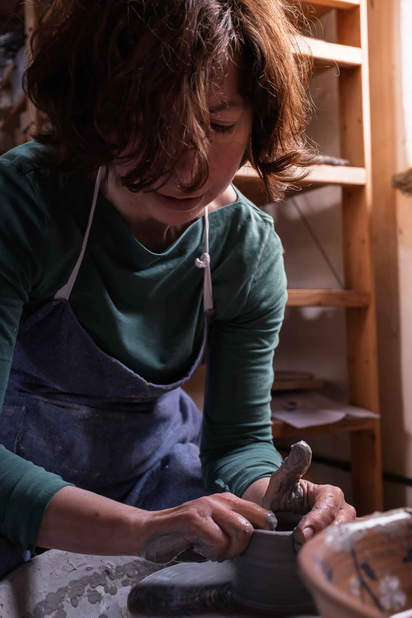 Acabado manual de una pieza de cerámica en el torno en el estudio de Lucía Catuxo en Trabada.