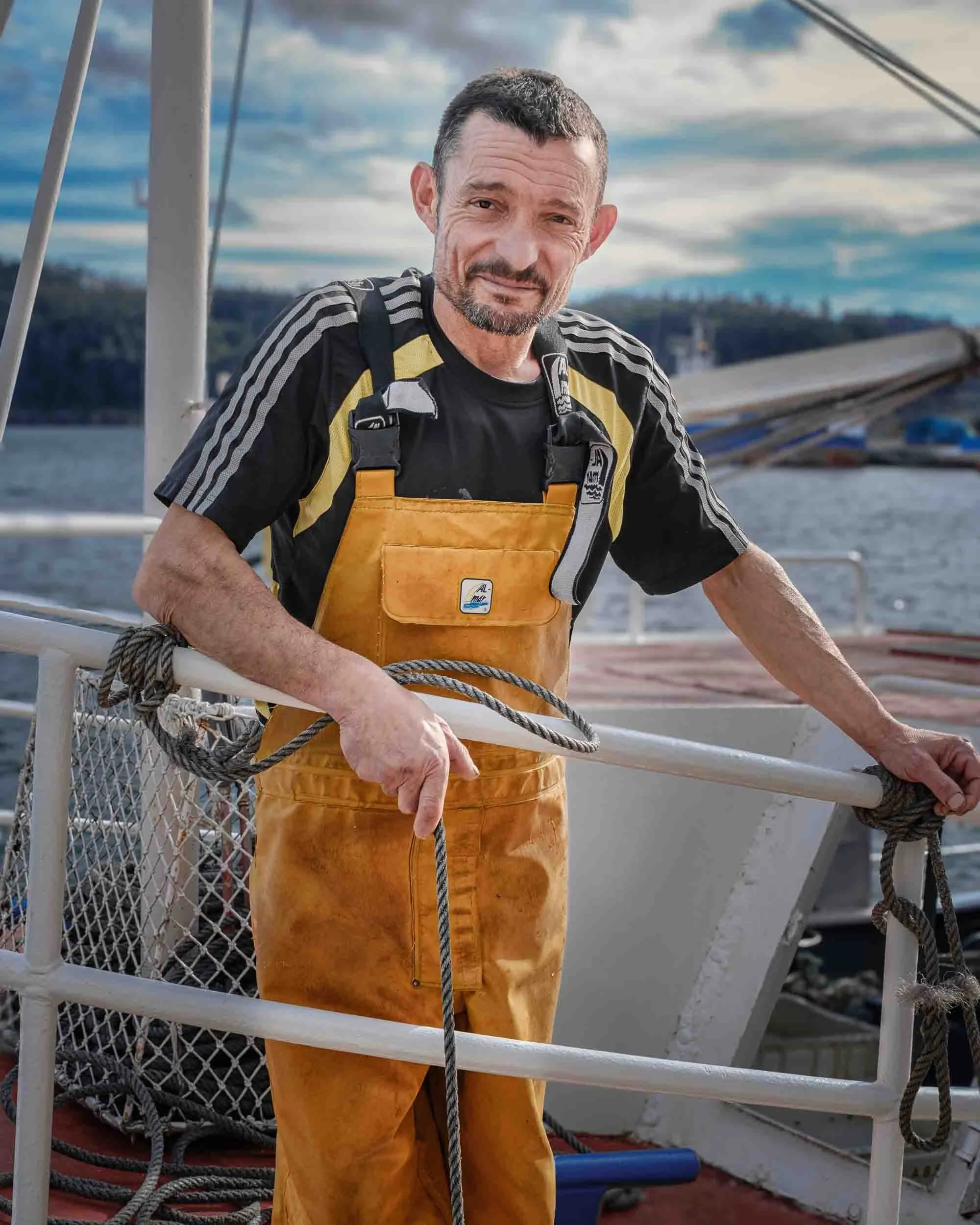 Retrato de un marinero de Cedeira a bordo de su embarcación, reflejando la vida en el puerto.