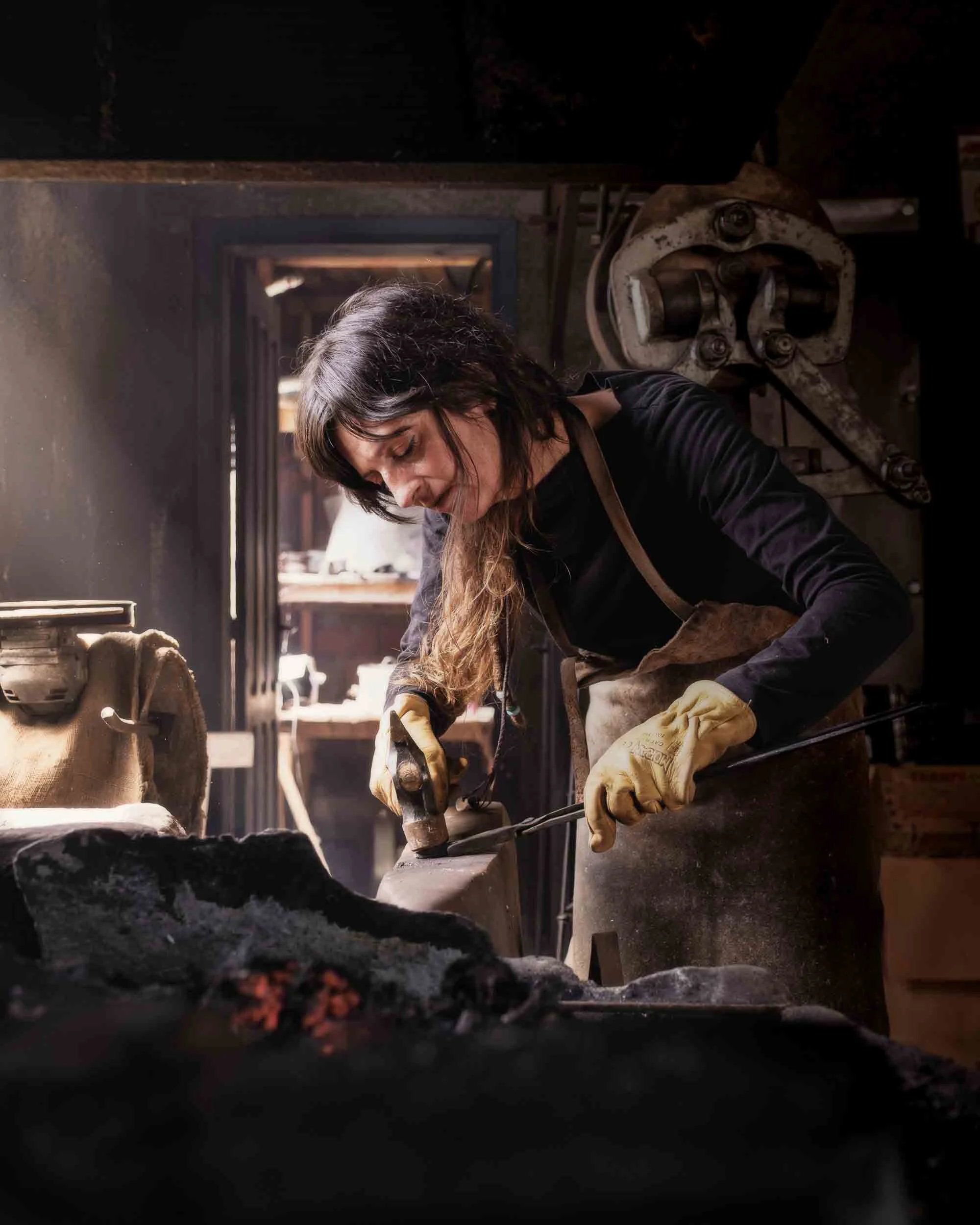 Fátima, la artesana de Arenaysal dando forma a un cuchillo artesanal en el yunque. Una muestra de la polivalencia y el talento multidisciplinar.