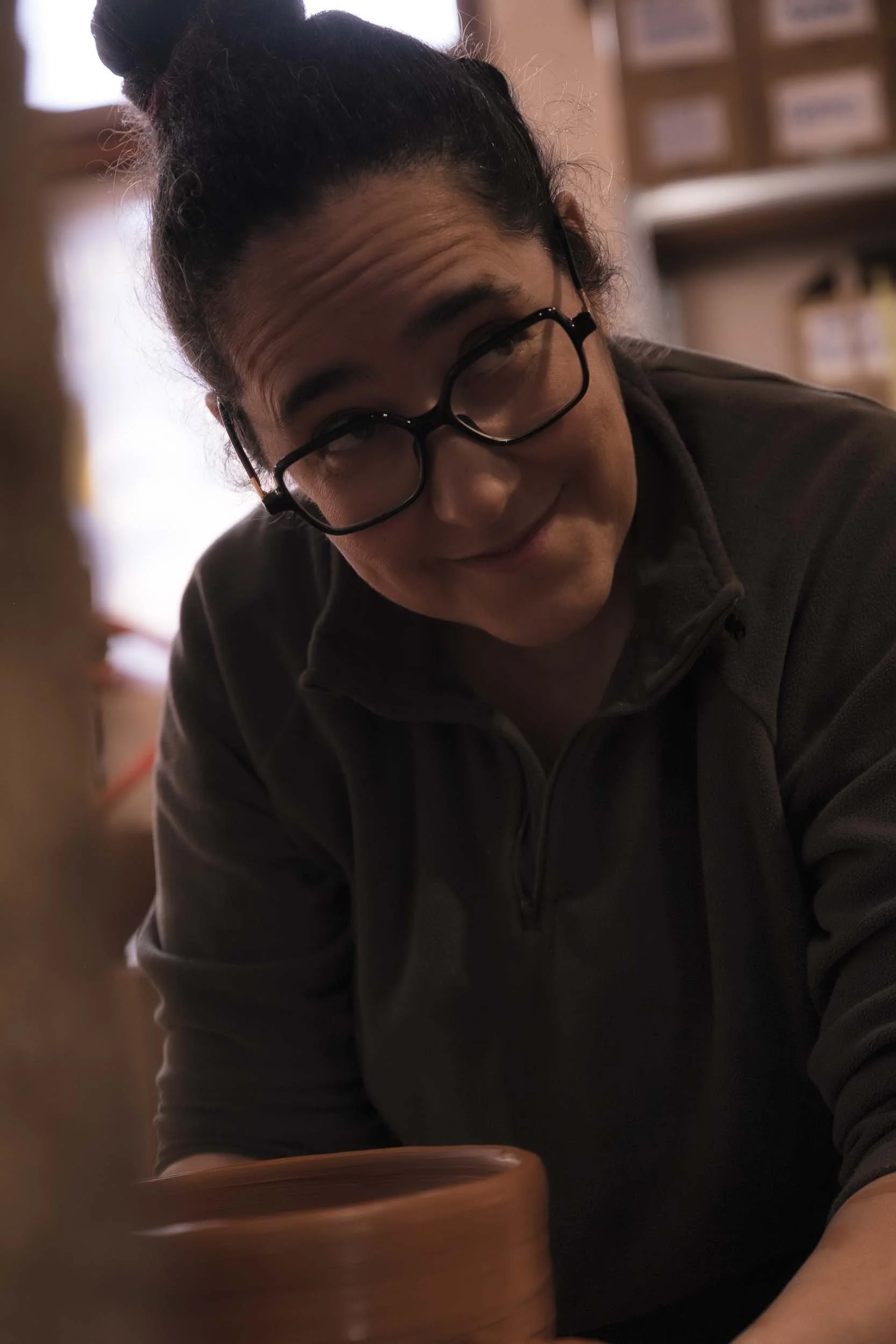 La ceramista Maica sonriendo y hablando en el taller de Esquina Atlántica. Una imagen que aporta calidez y humanidad al reportaje.