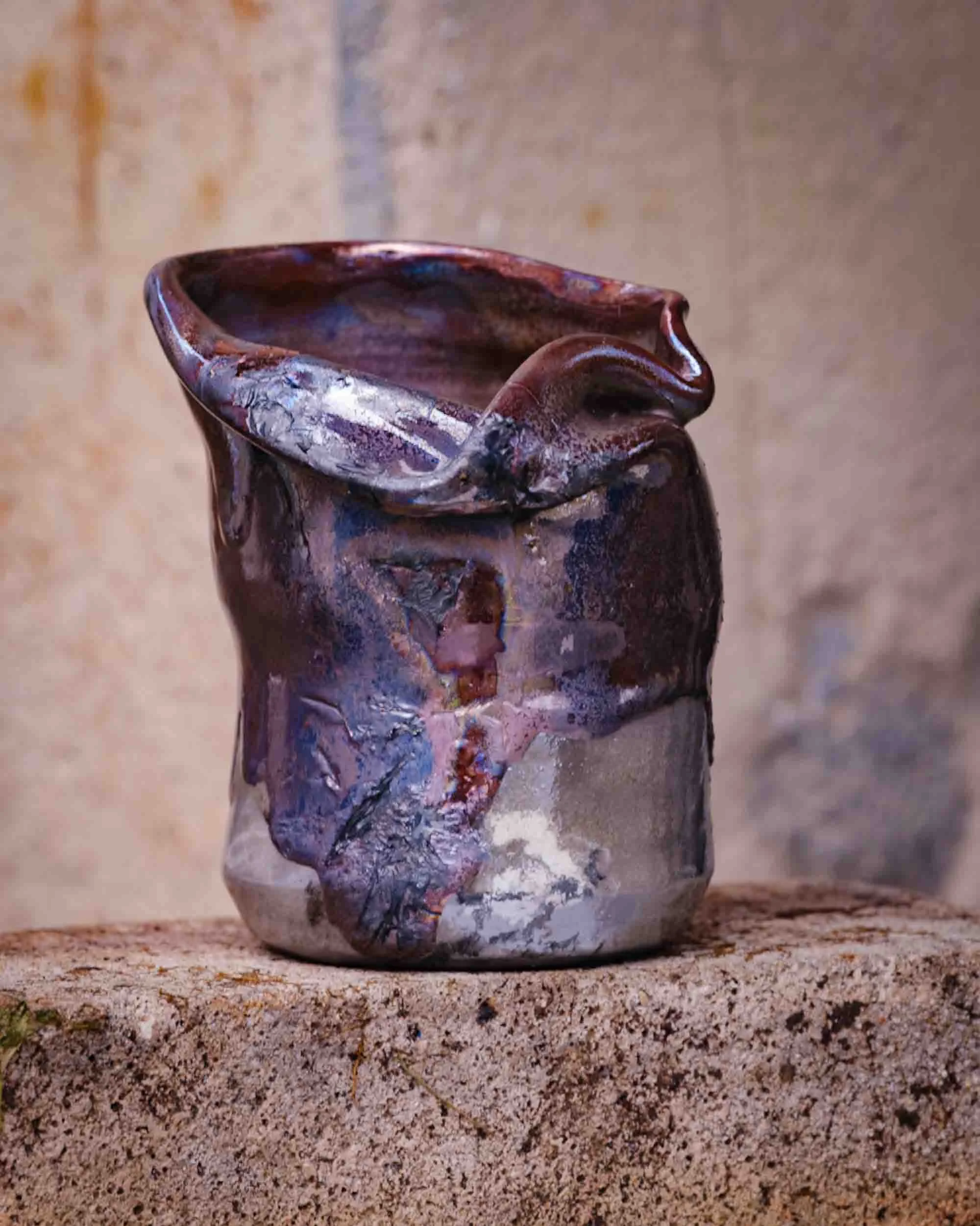 Jarra de cerámica artesanal con esmaltes metálicos y formas orgánicas siguiendo la estética Wabi-Sabi.