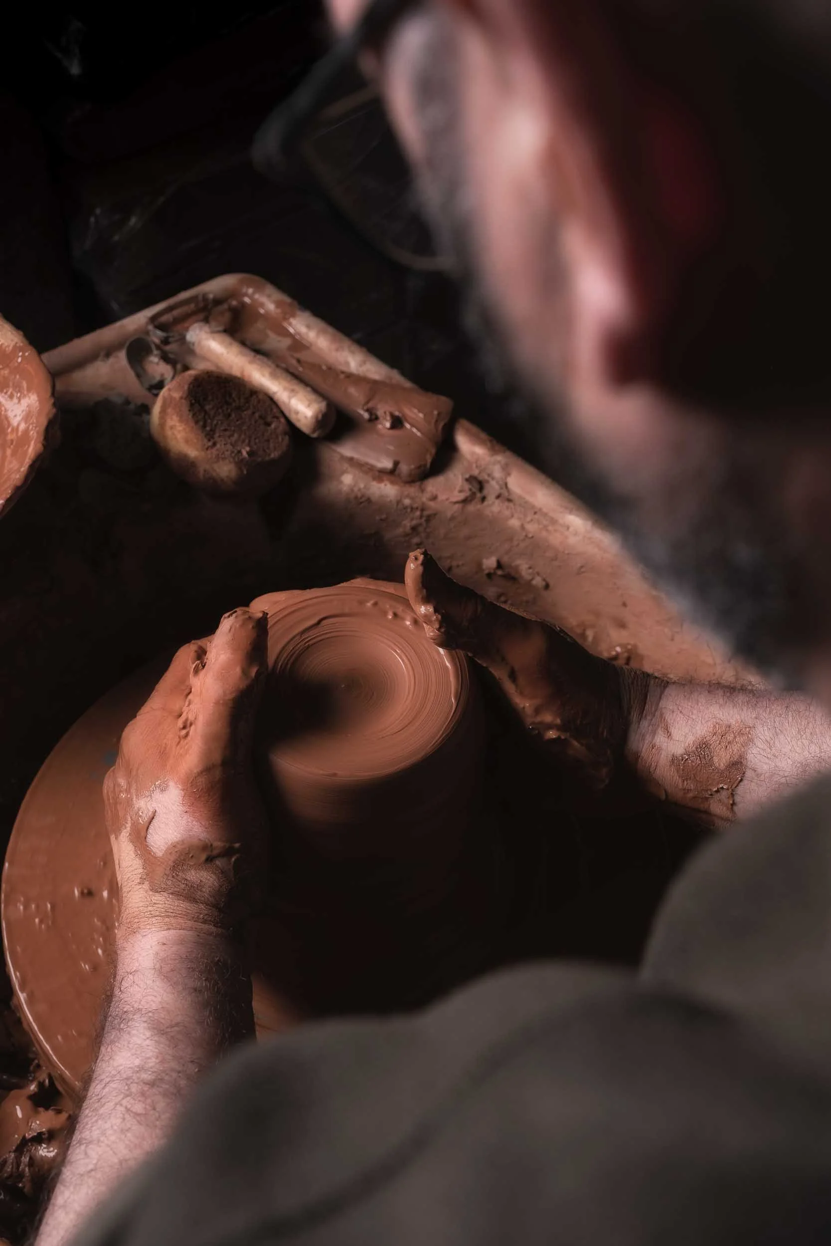 Primer plano de una pieza de cerámica naciendo en el torno. Perspectiva centrada en el material y la forma, estilo Photorural.
