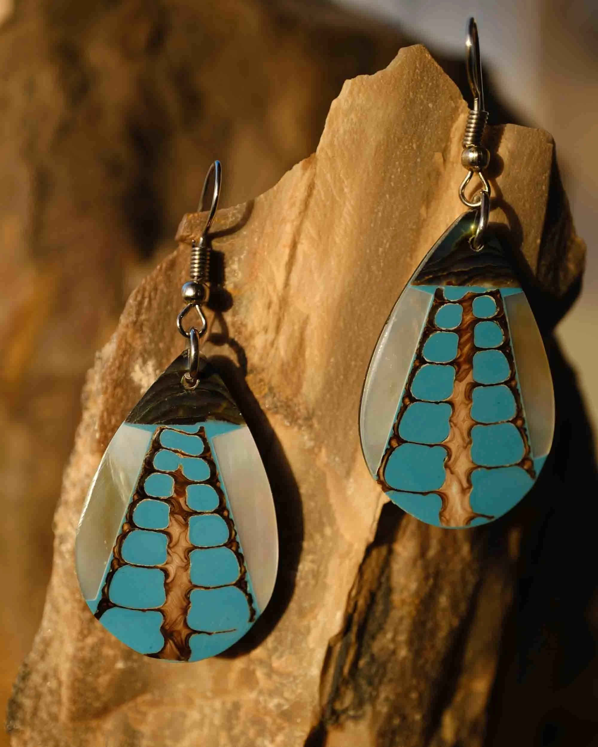 Primer plano de pendientes artesanales con diseño étnico y acabado rústico, resaltando texturas metálicas y detalles hechos a mano.