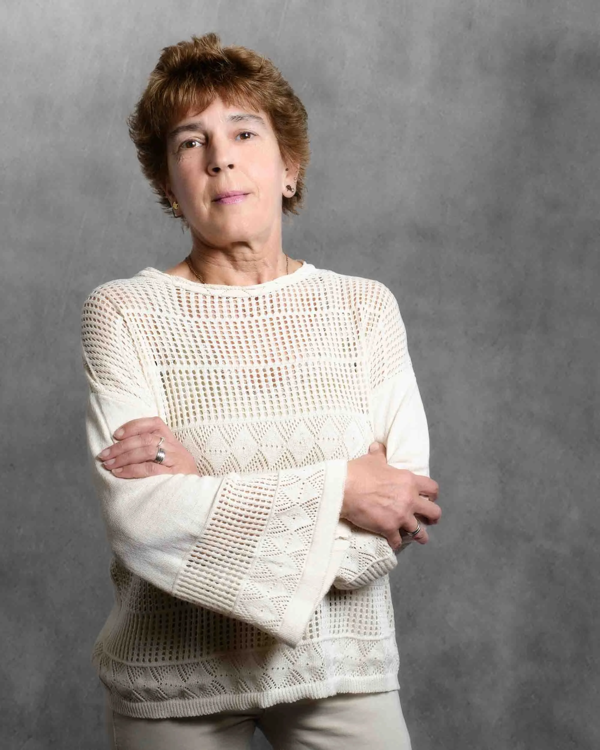 Retrato de candidata municipal. Pose de brazos cruzados que comunica determinación y profesionalismo, con iluminación suave de estilo editorial.