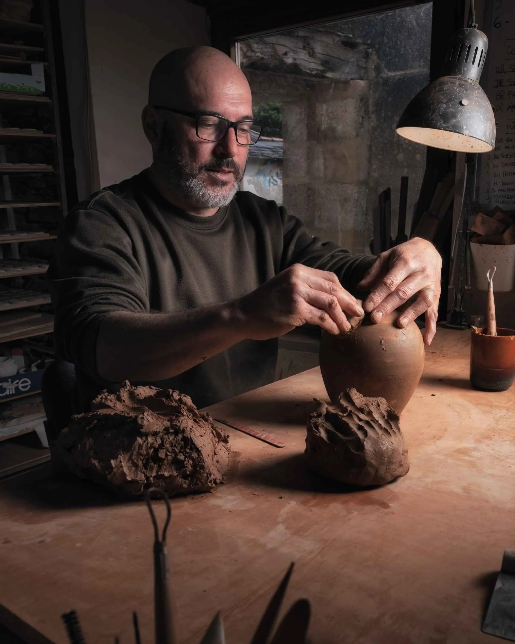 Alfarero tradicional moldeando una pieza de cerámica, capturando el movimiento y la precisión del oficio.