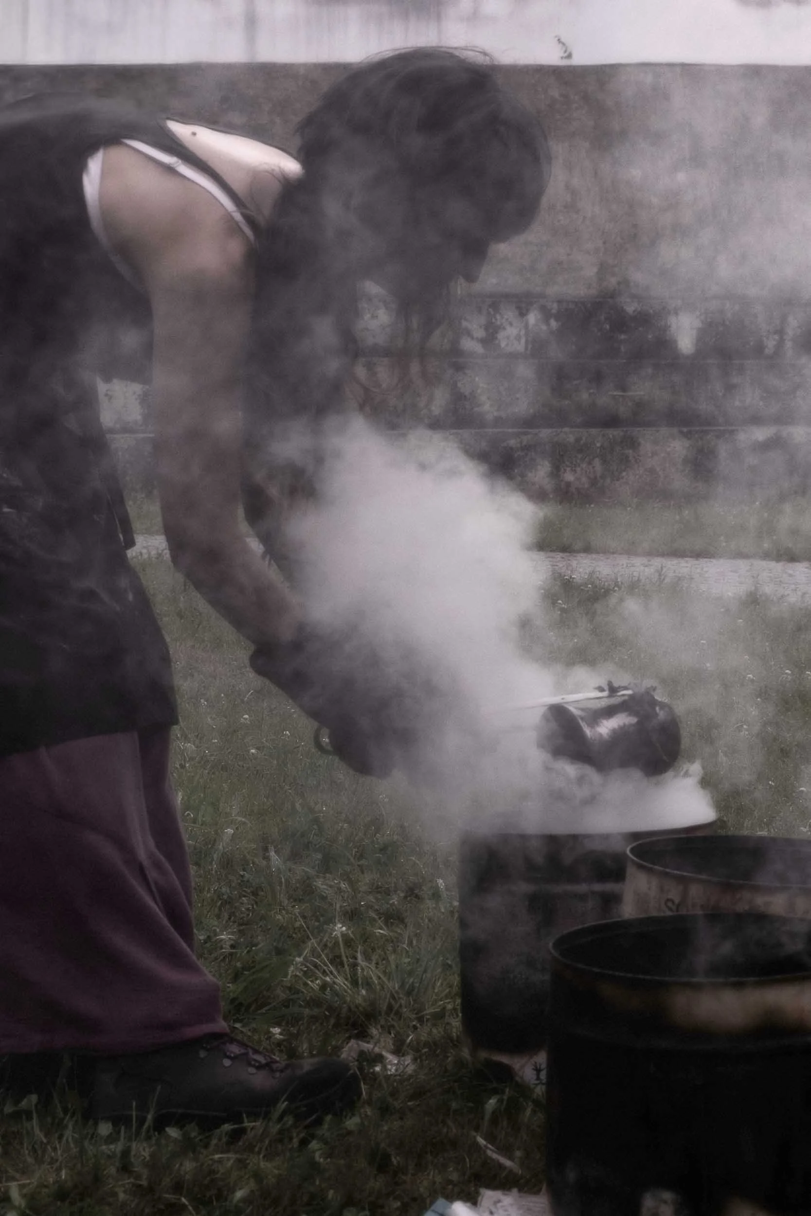 Una vasija de cerámica Raku al rojo vivo siendo enfriada tras salir del horno, mostrando el efecto del choque térmico y la reducción. Fotografía de autor que captura la magia del fuego.