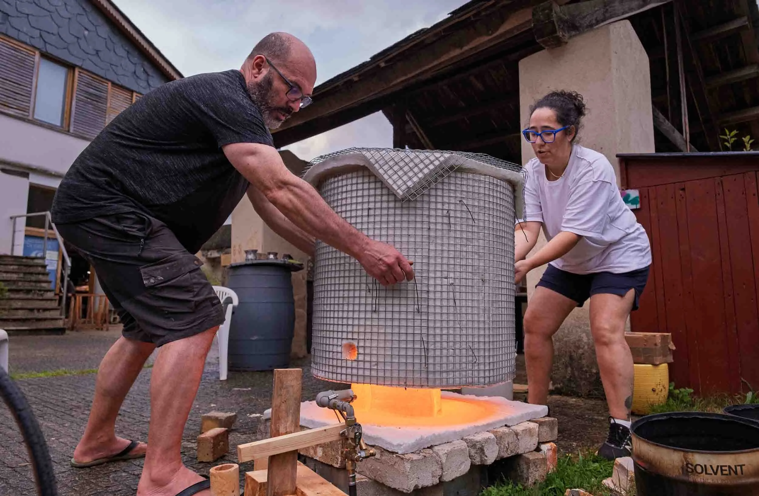 Marcelo y Maica cociendo piezas artesanales en horno con técnica Rakú en su alfar de Os Muiños en Mondoñedo