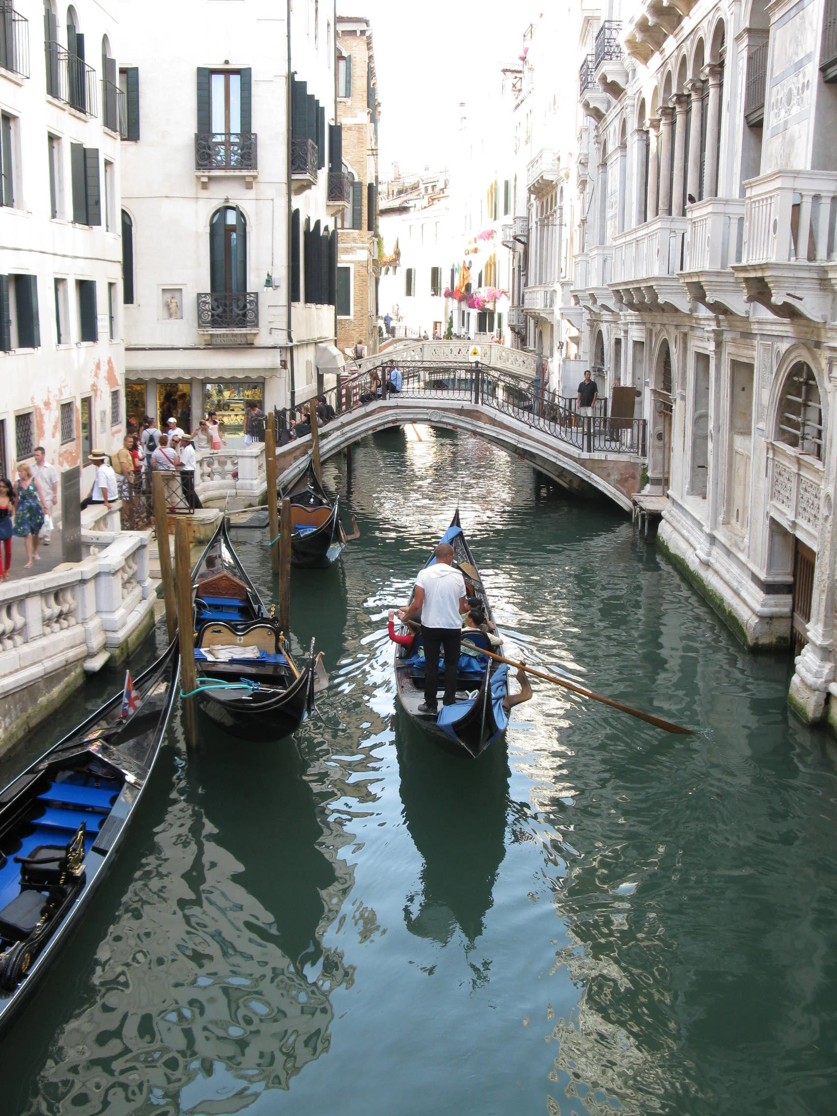 Gondola traveling along a narrow canal between historic buildings in Venice, Italy