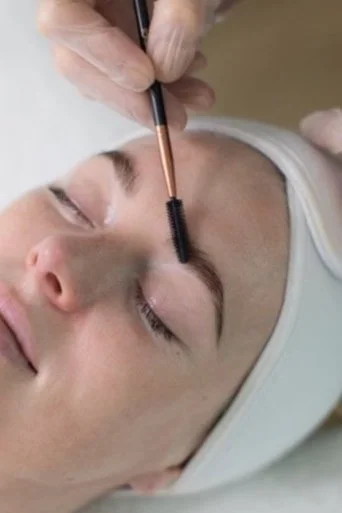 A person receiving an eyebrow lamination, waxing and tinting treatment with an esthetician at a salon in Medford, OR.
