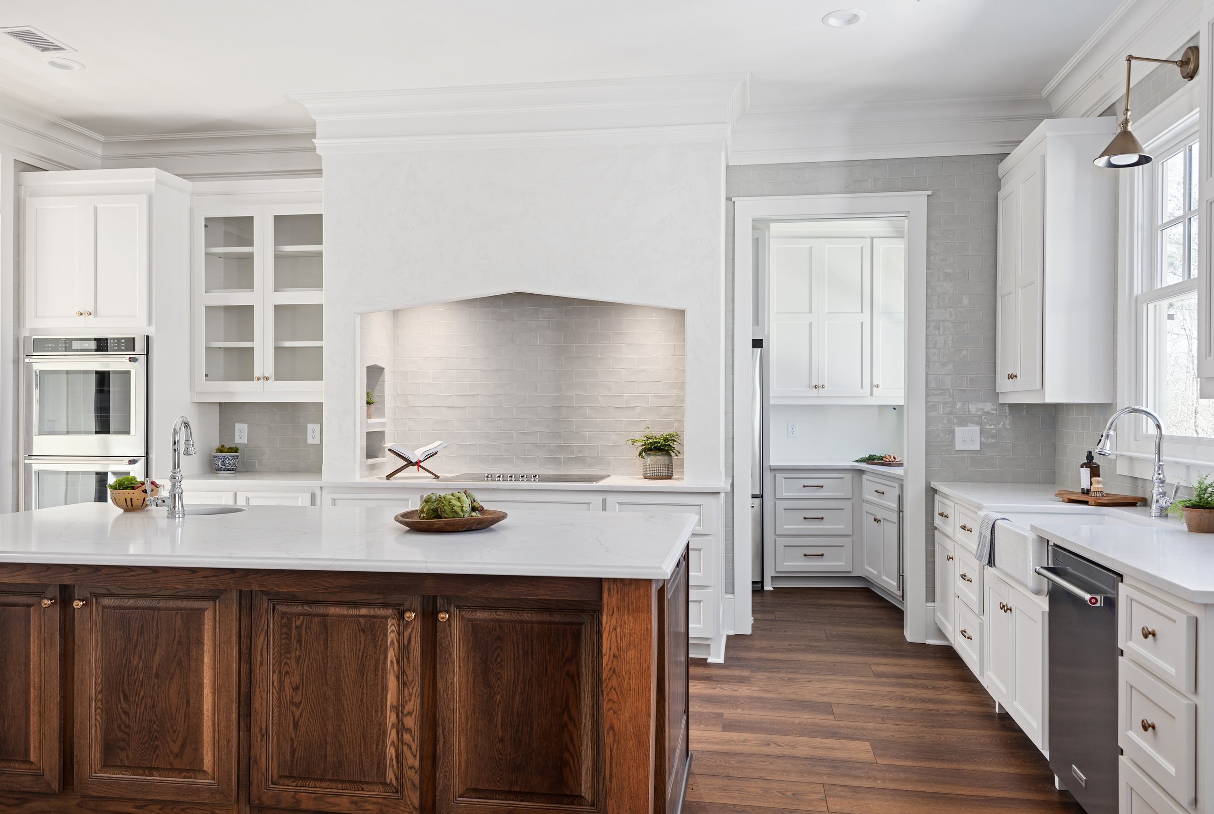 Custom kitchen renovation in Columbus, Georgia with white cabinetry and dark wood island