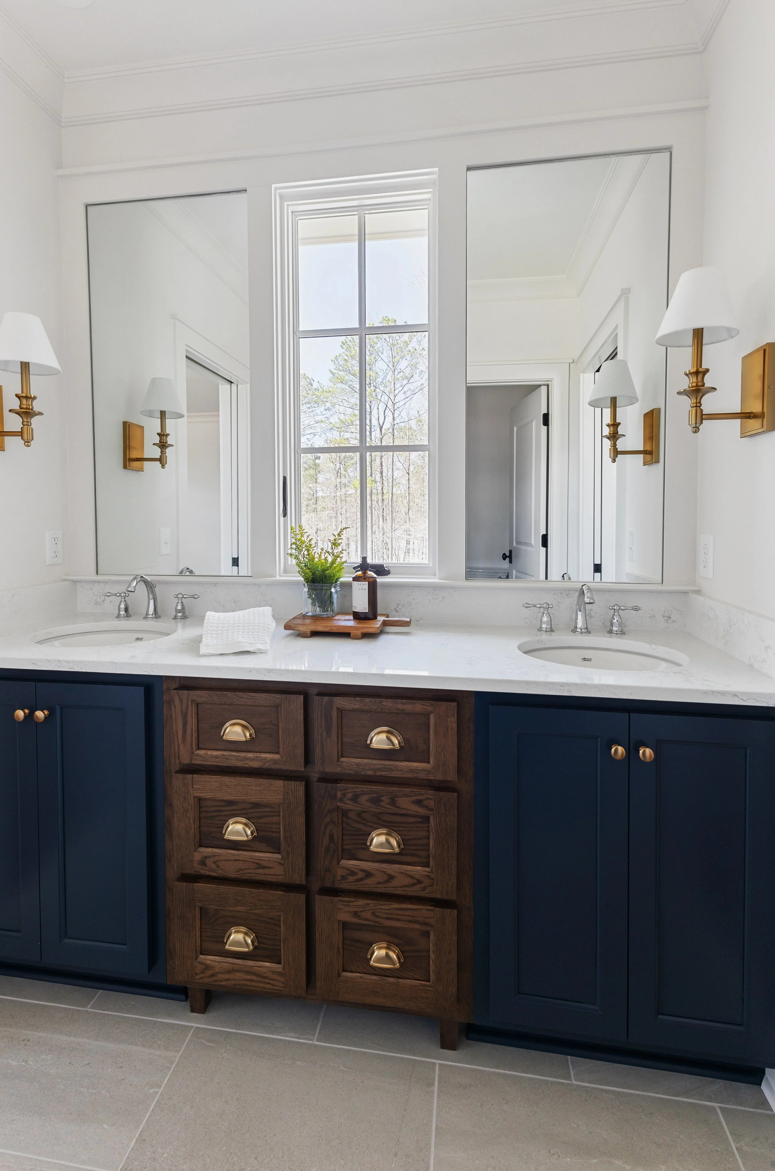 Bathroom renovation with navy vanity and brass fixtures in Columbus Georgia