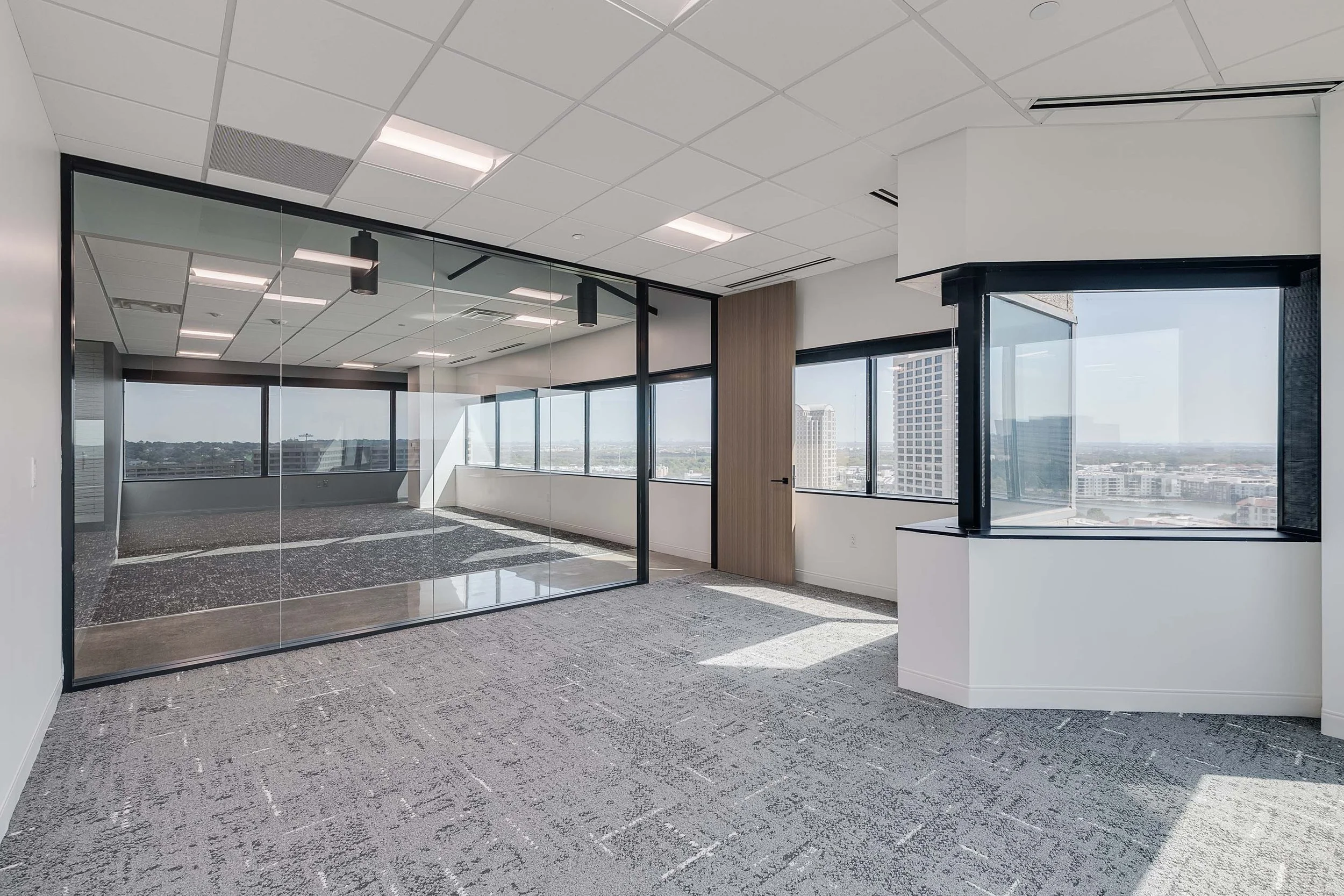 Empty spec suite. Half of room sectioned off by glass wall creating private room.