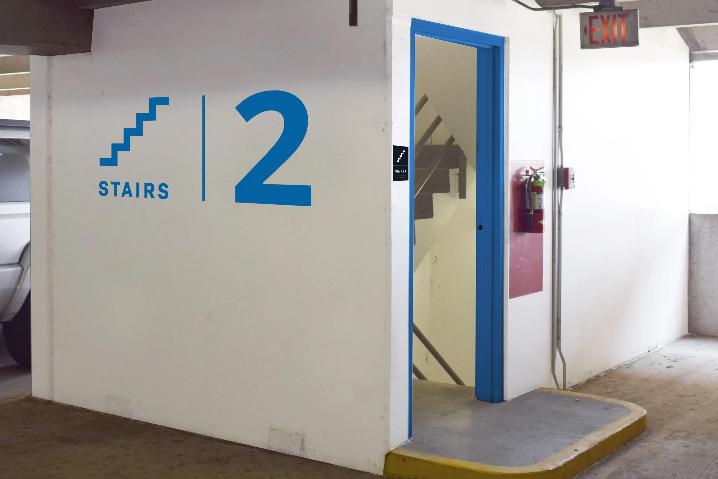 Stair 2 painted signage on wall next to stairs in parking garage.