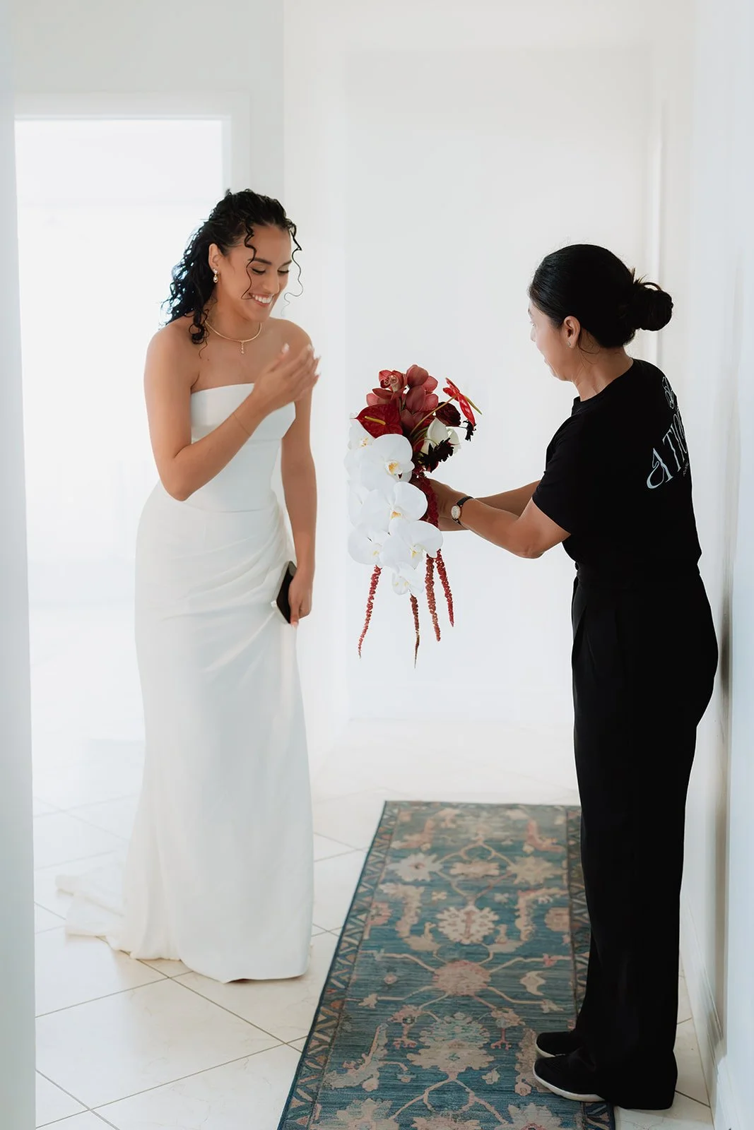 Bridal bouquet featuring white phalaenopsis orchids and burgundy floral accents.