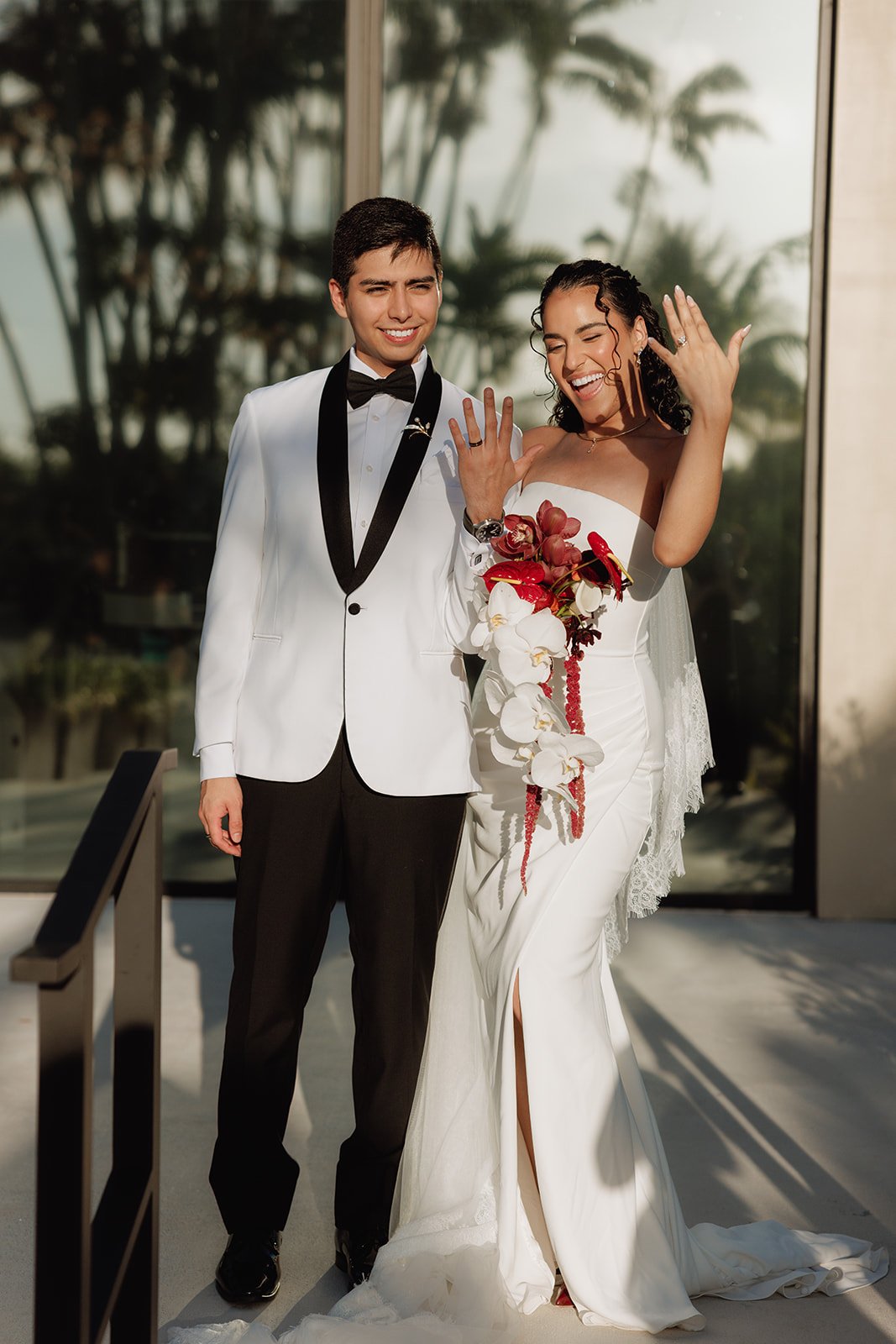 Bride holding an elegant cascading orchid bouquet during a luxury outdoor wedding in South Florida with romantic sunset lighting.