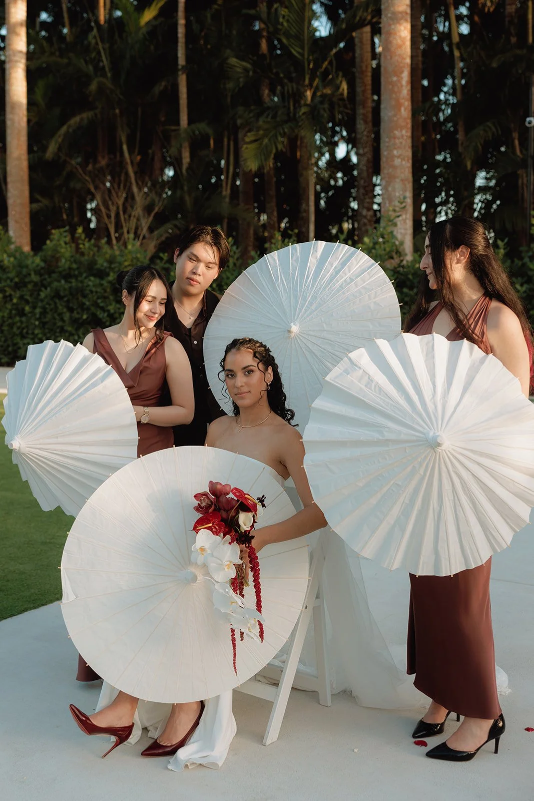 Bride holding an elegant cascading orchid bouquet during a luxury outdoor wedding in South Florida with romantic sunset lighting.